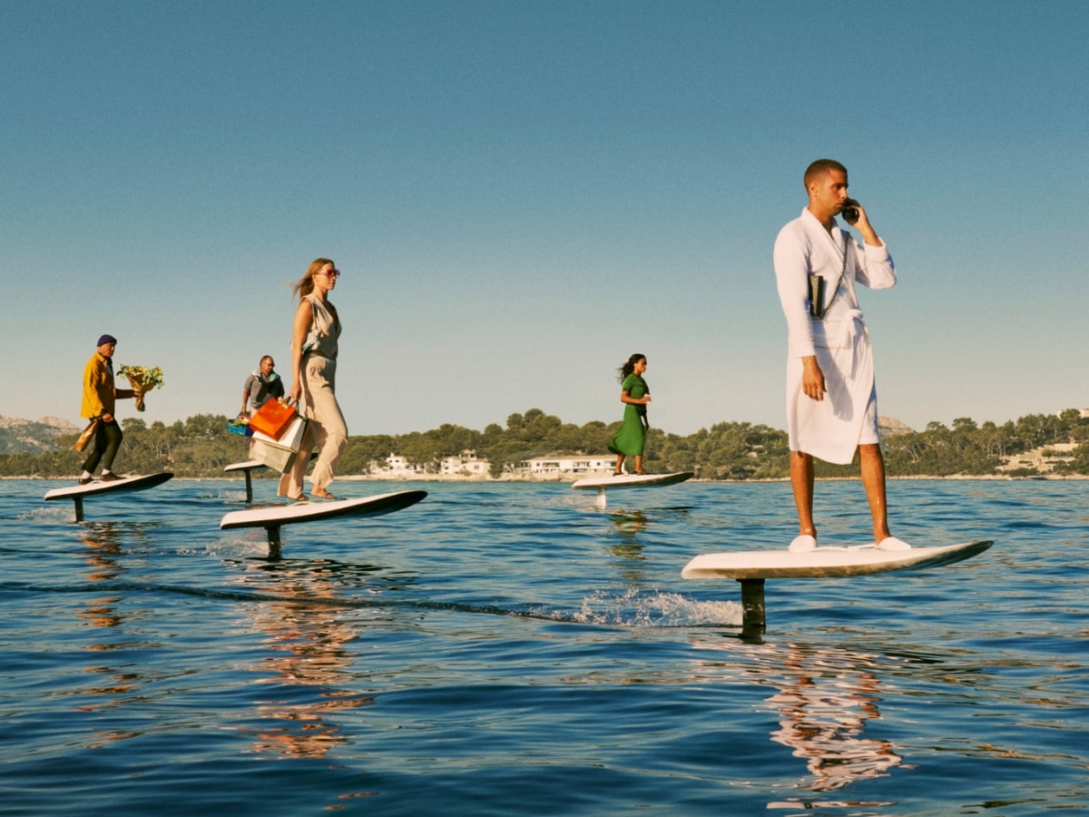 Five people dressed in different outfits surfing towards a destination
